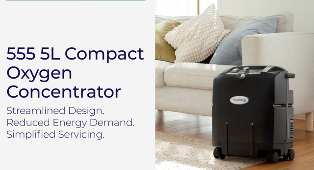 A black DeVilbiss 555 5L Compact Oxygen Concentrator shown in a living room setting next to a white sofa, with text on the left describing its features.